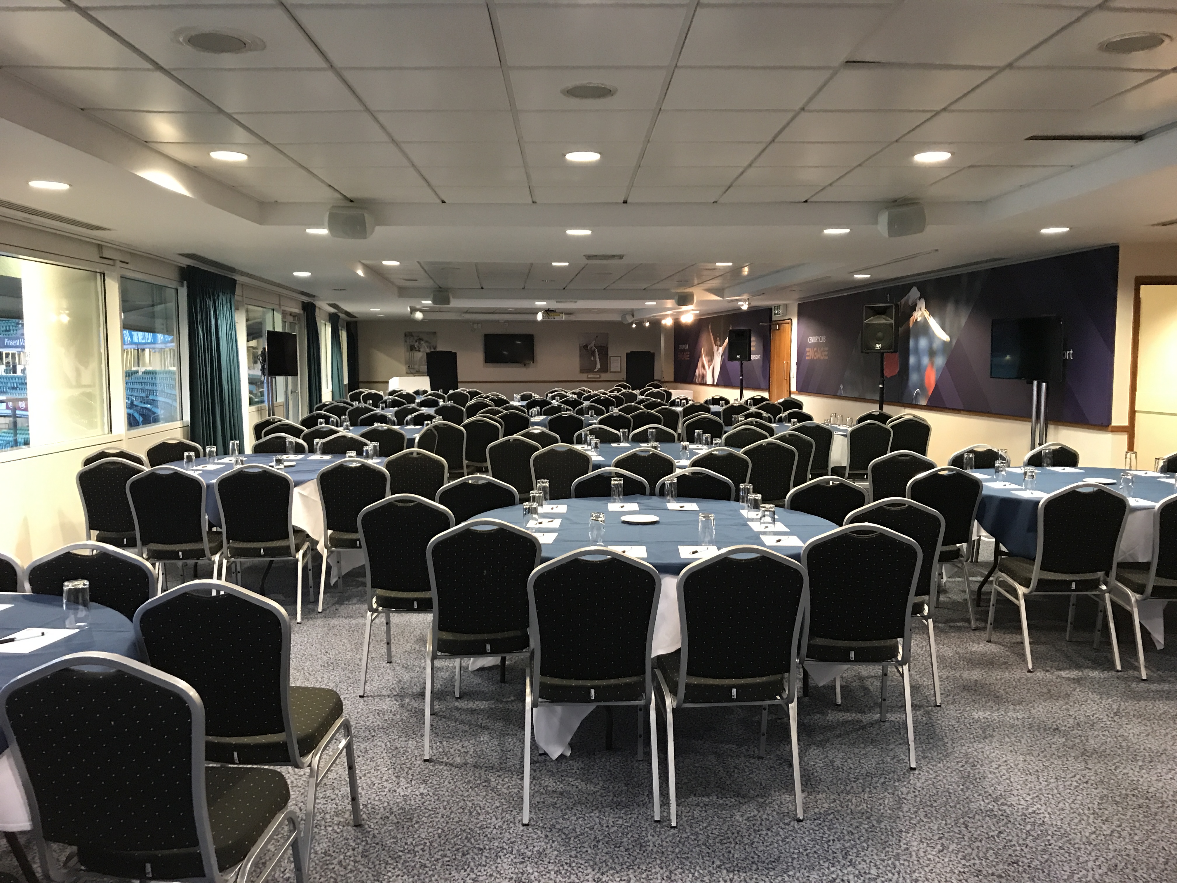 John Major Room at Kia Oval, set for a conference with blue tablecloths and AV equipment.
