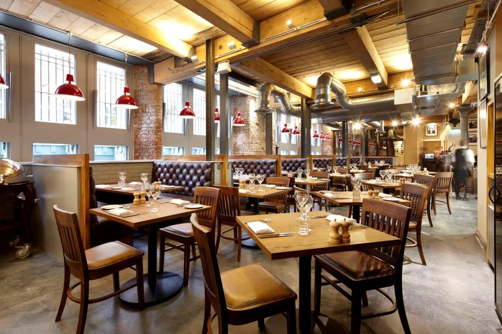 Stylish restaurant with wooden tables, ideal for intimate gatherings and corporate events.