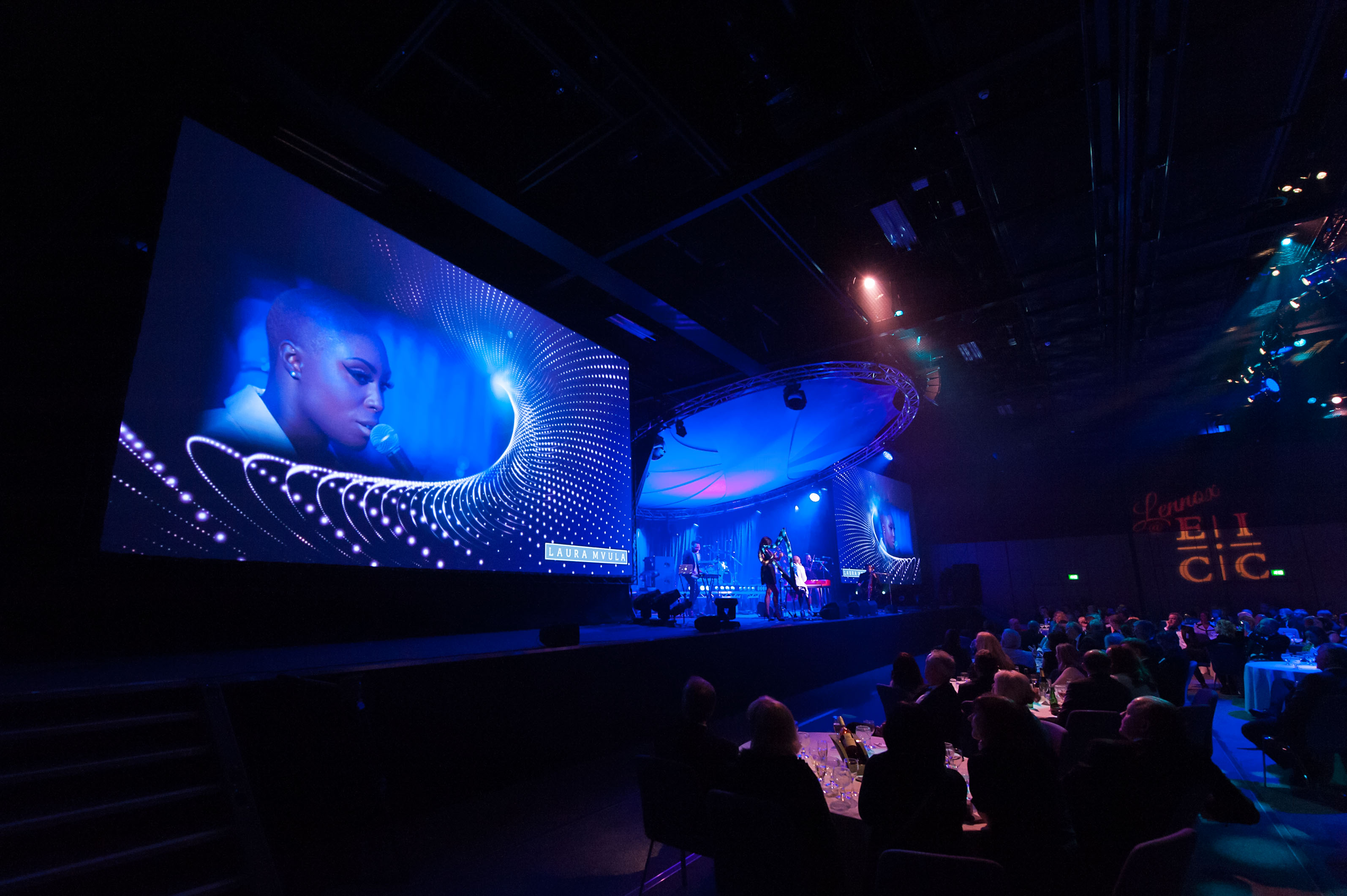 Lennox Suite event in Edinburgh with vibrant lighting and engaged audience.
