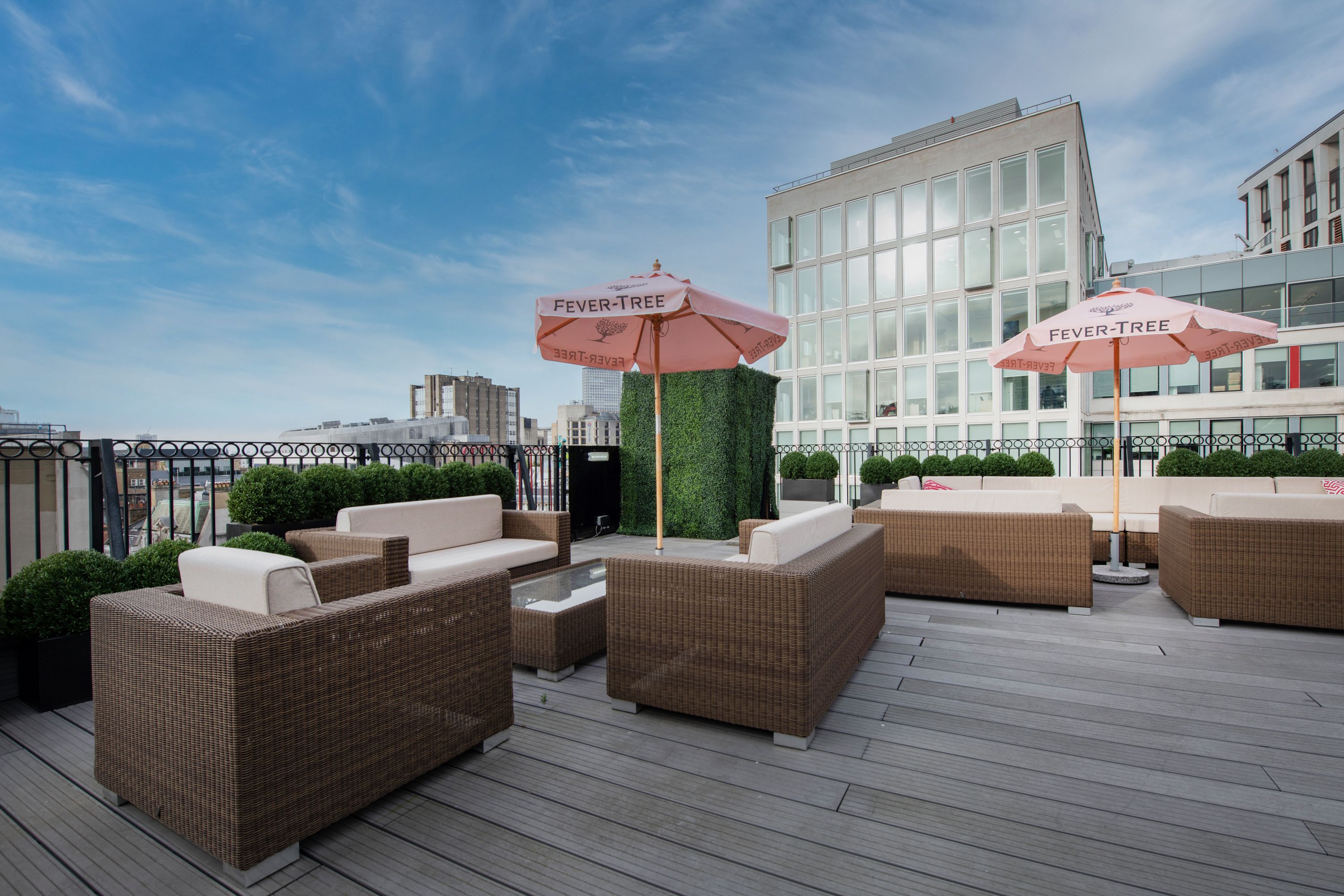 Stylish rooftop event space with pink umbrellas at De Vere Grand Connaught Rooms.