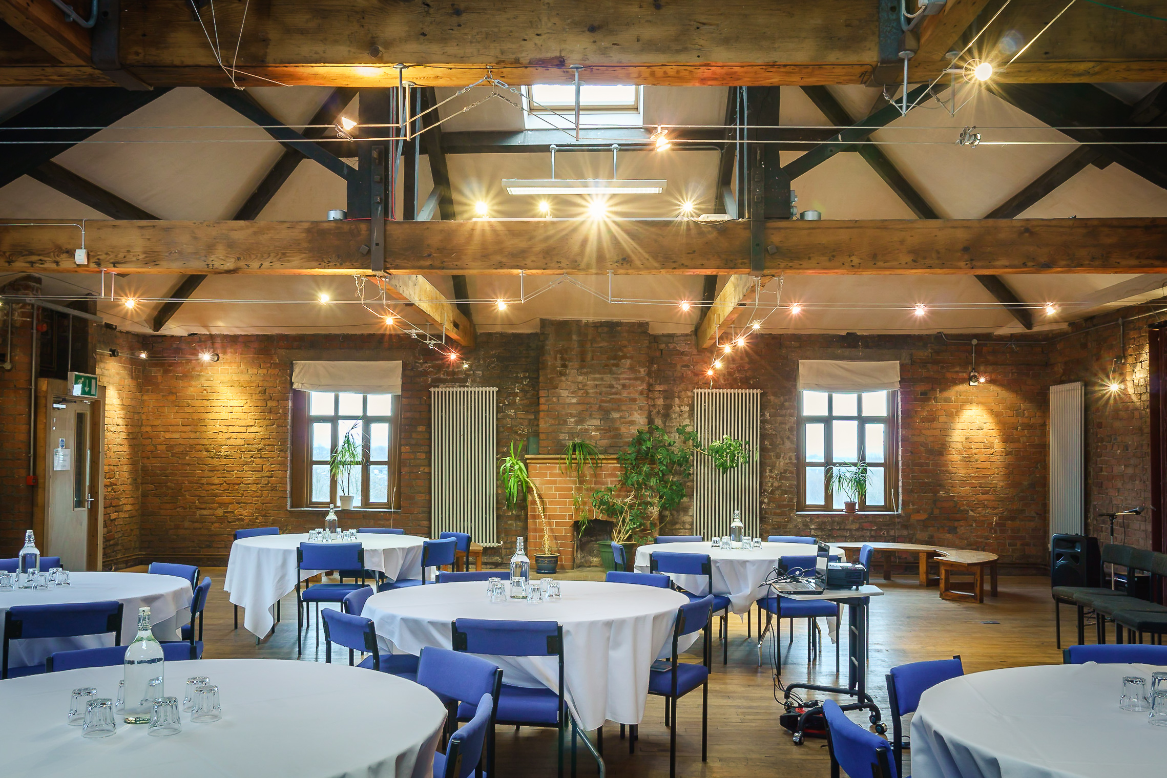 Silk Loft event space with round tables, natural light, ideal for meetings and networking.