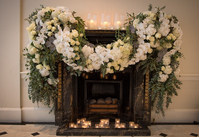 Elegant fireplace with white orchids in Marble Hall, perfect for upscale events.