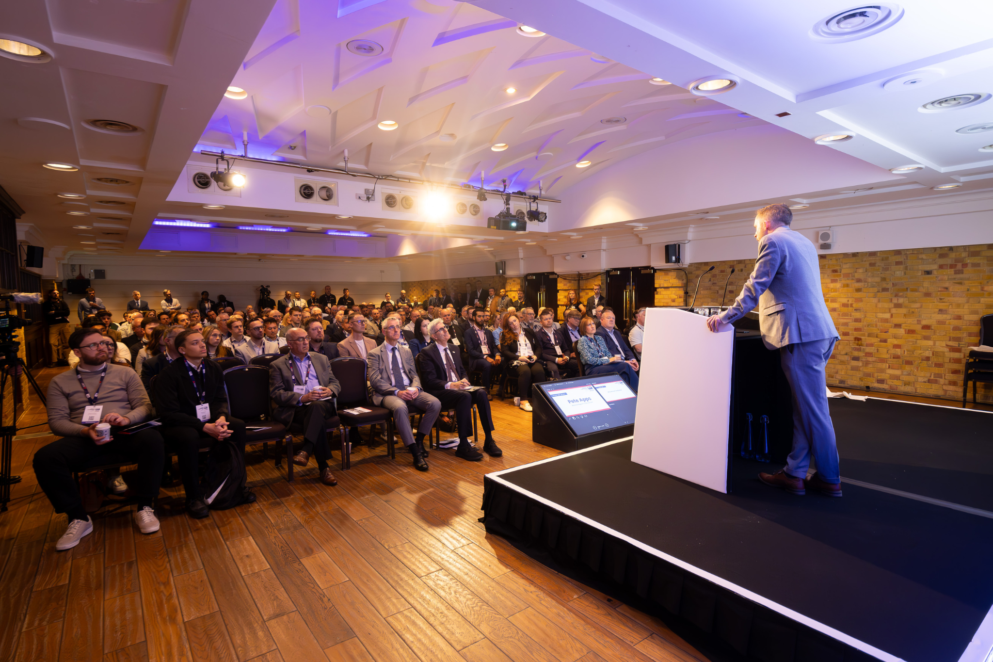 Engaging conference session at The Queen Charlotte with focused audience and speaker.