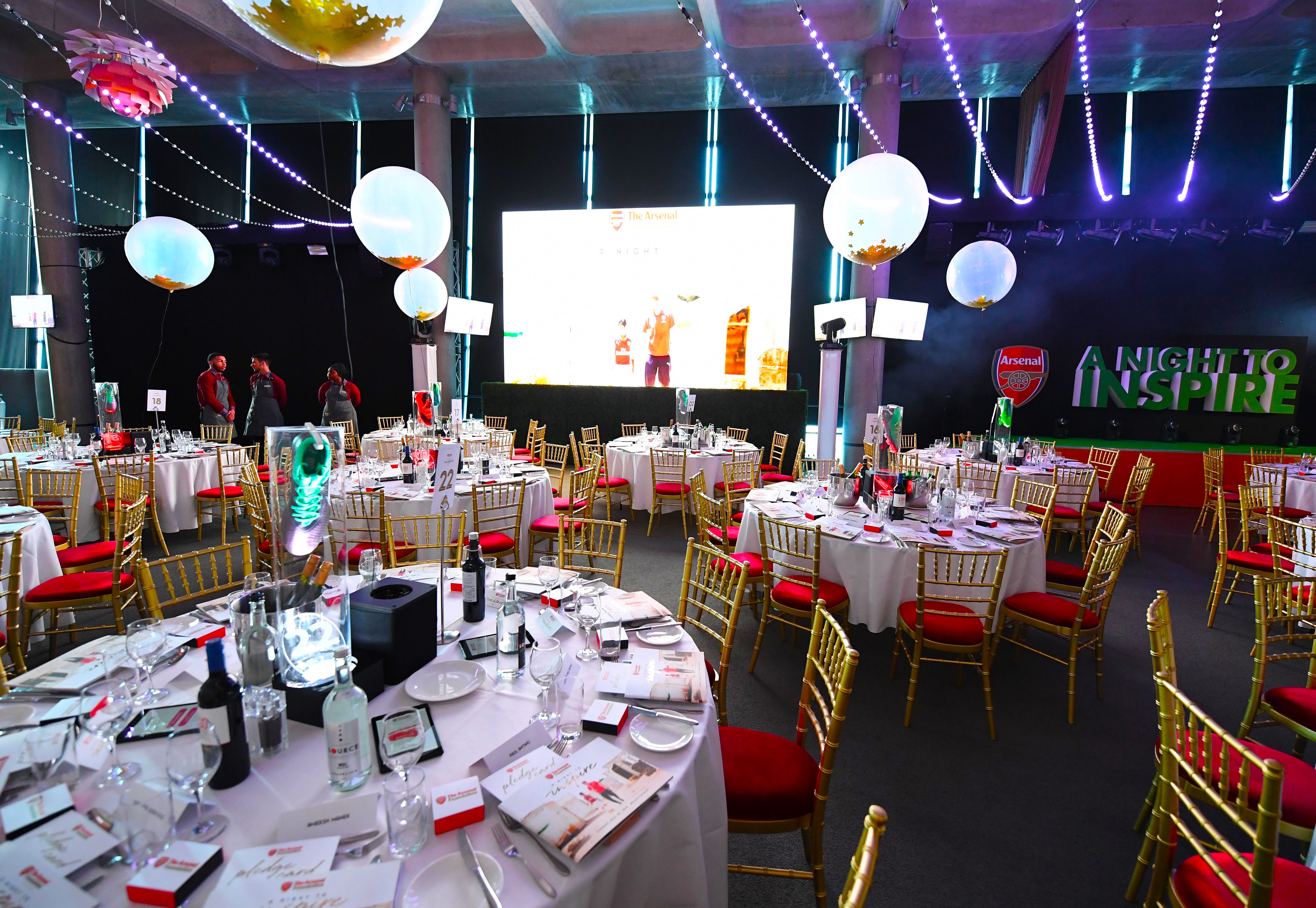 Elegant dinner setup at Emirates Stadium with gold chairs for corporate events.