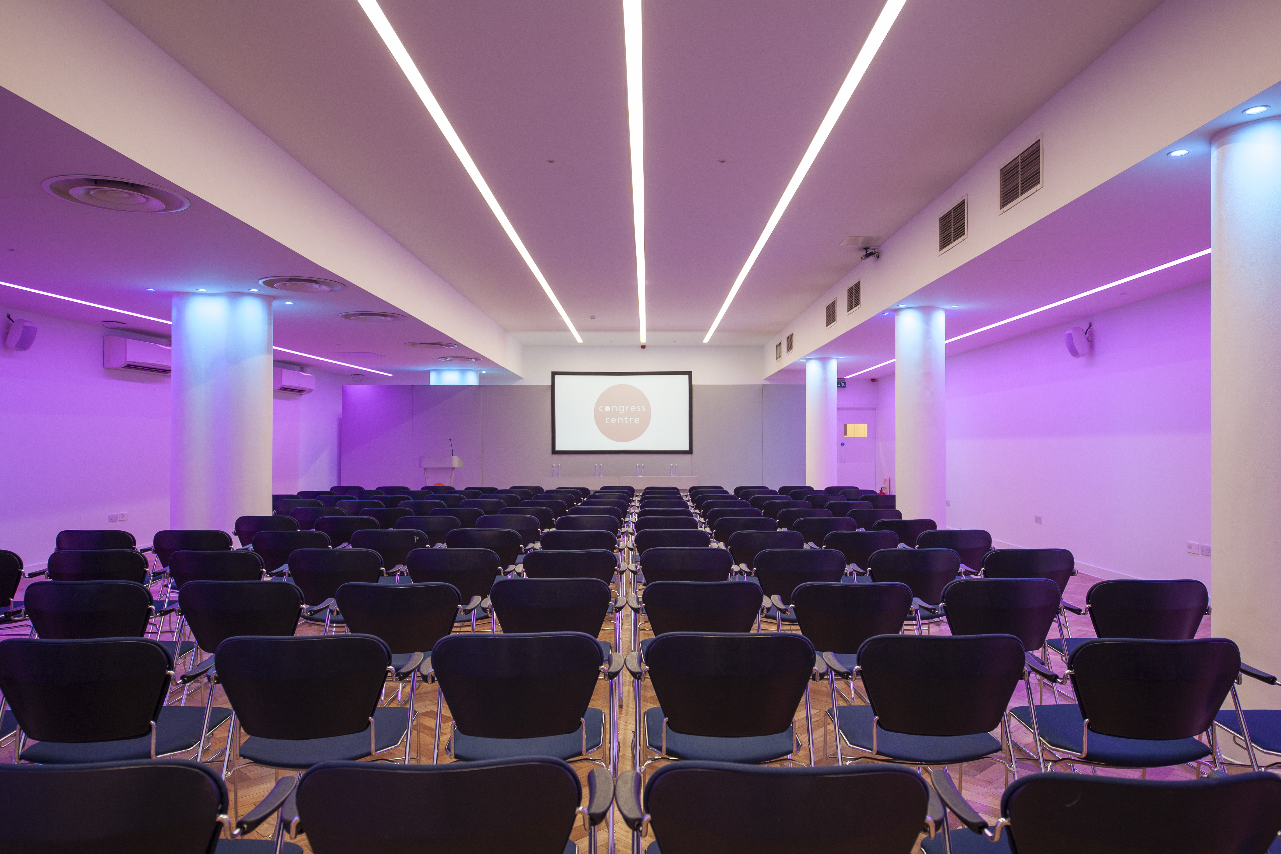 Modern Congress Suite with black chairs and purple lighting for presentations and conferences.