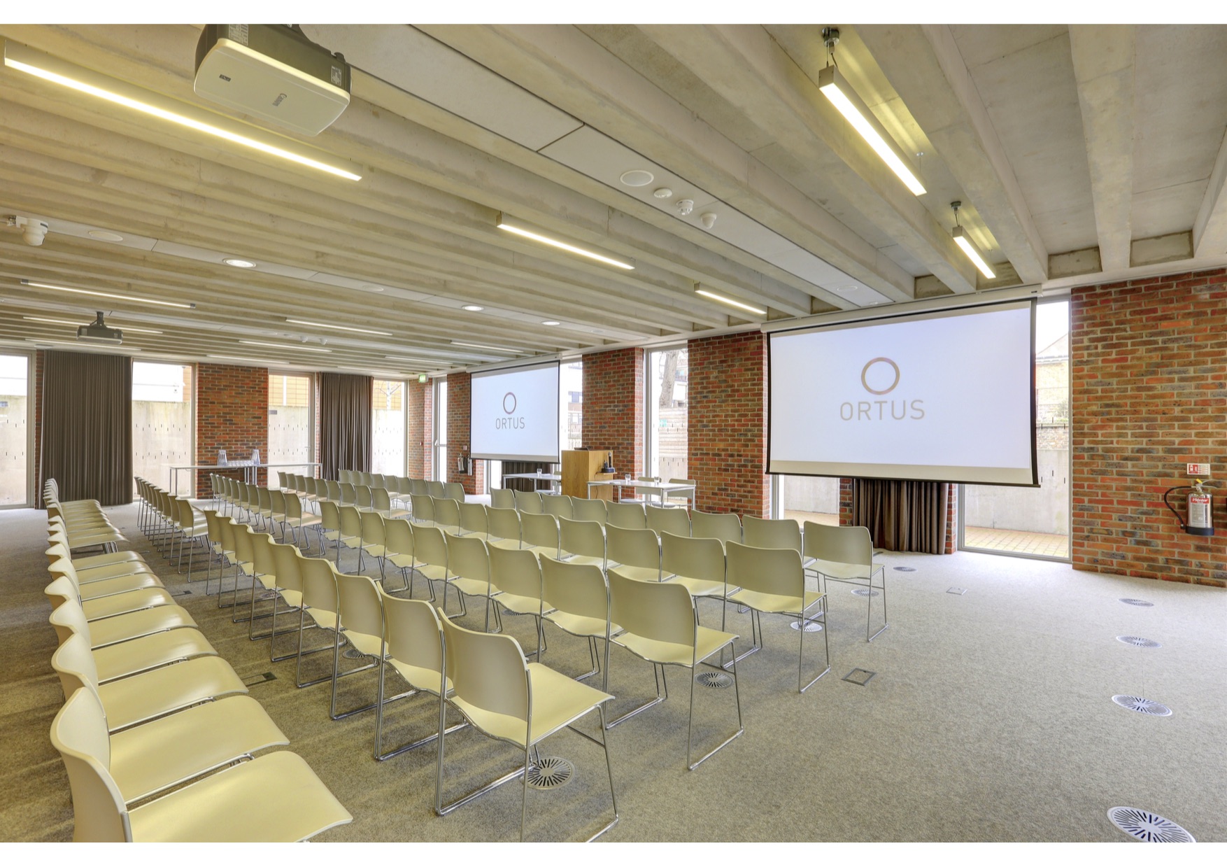 Modern event space with chairs and large screens at ORTUS Conference Venue.
