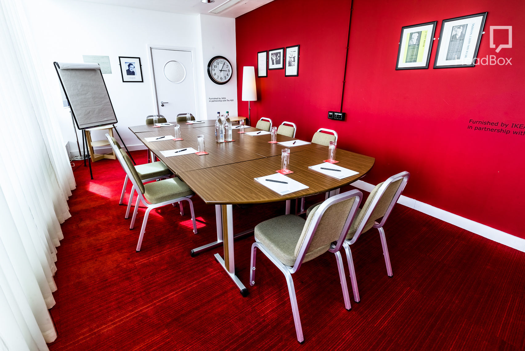 Modern conference room in Birmingham with vibrant red wall for strategic meetings.