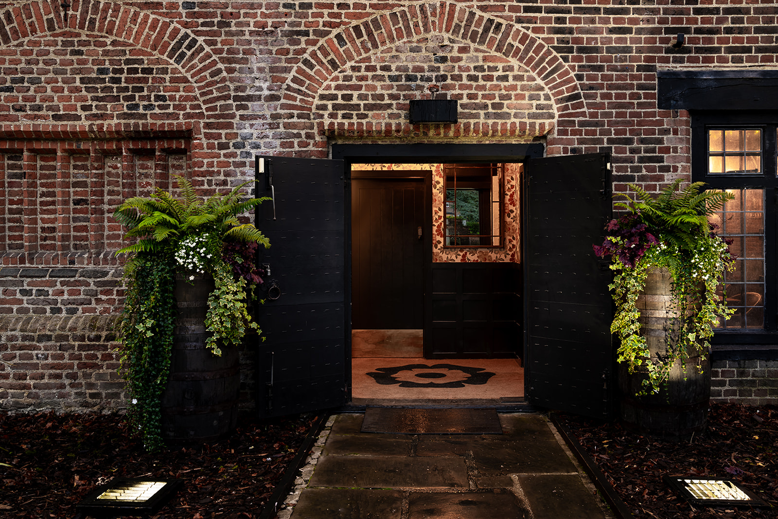 Inviting Tudor Barn Eltham entrance with rustic brick and elegant doors for events.