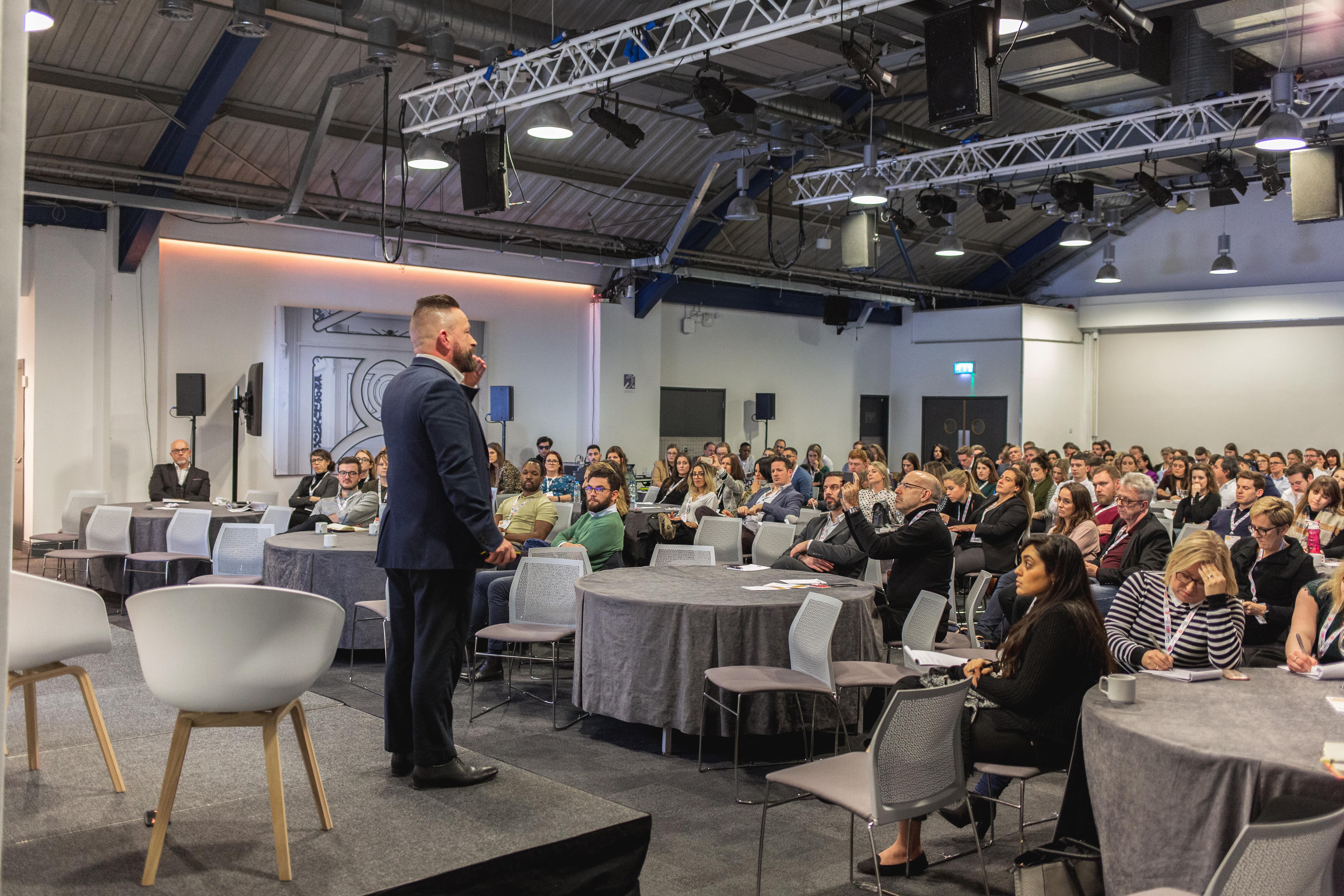 Auditorium at Business Design Centre during a conference with engaged audience and modern lighting.
