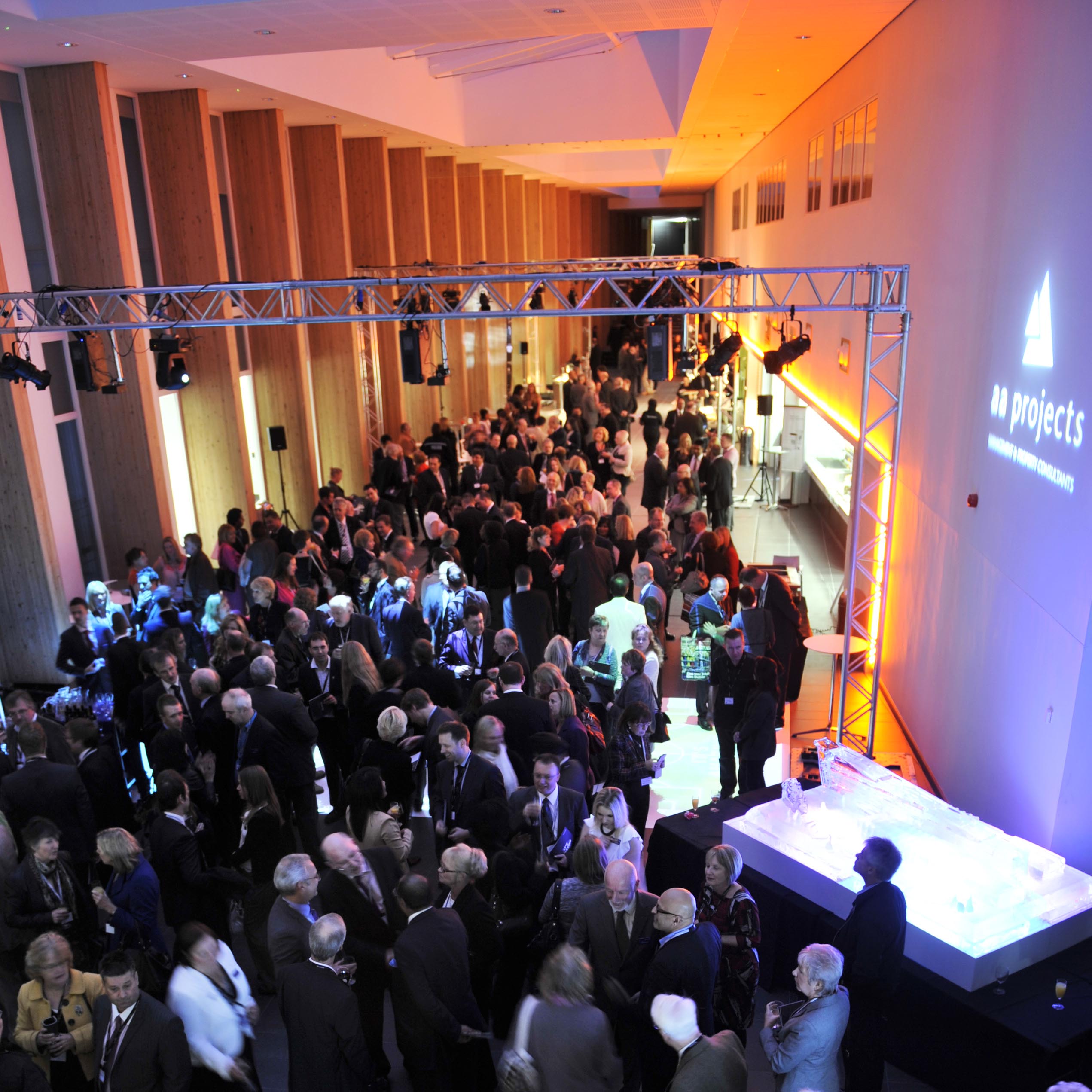 Networking event at Bournville College with ice sculpture centerpiece and vibrant atmosphere.